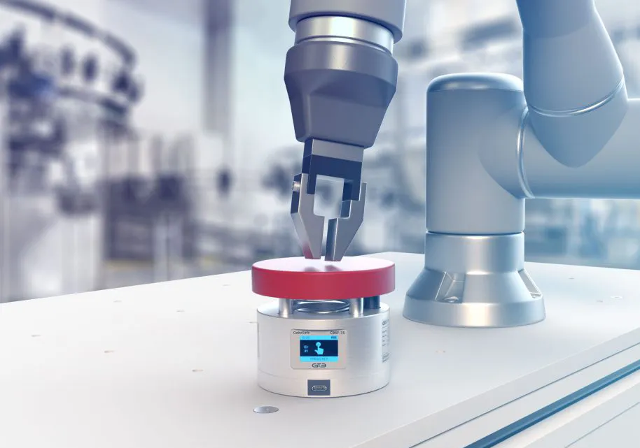 Cobot arm fitted with a CoboSafe force and pressure transducer on a workbench