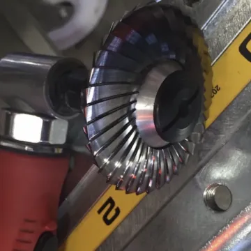 Close-up of a double-sided milling disc mounted on an angle grinder, cutting a weld preparation
