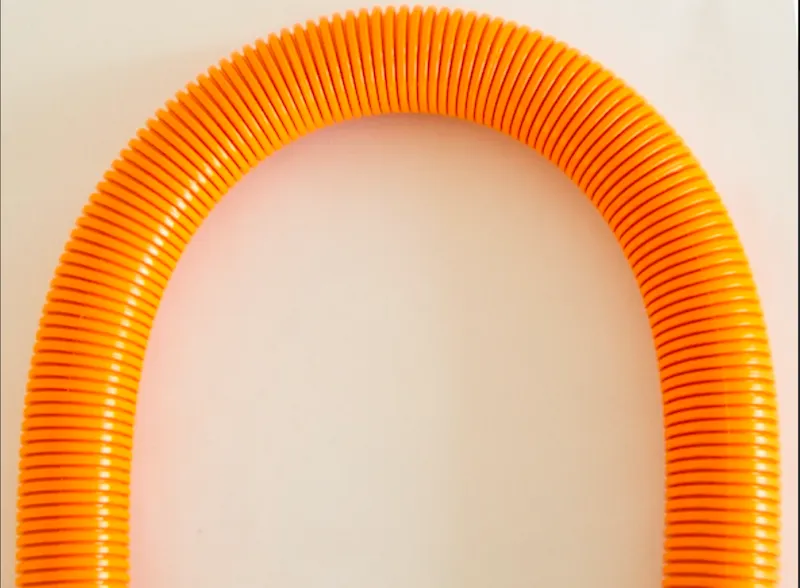 Orange PA12 outer hose bent into a tight U-shape, demonstrating the 70 mm minimum bending radius with no kinking