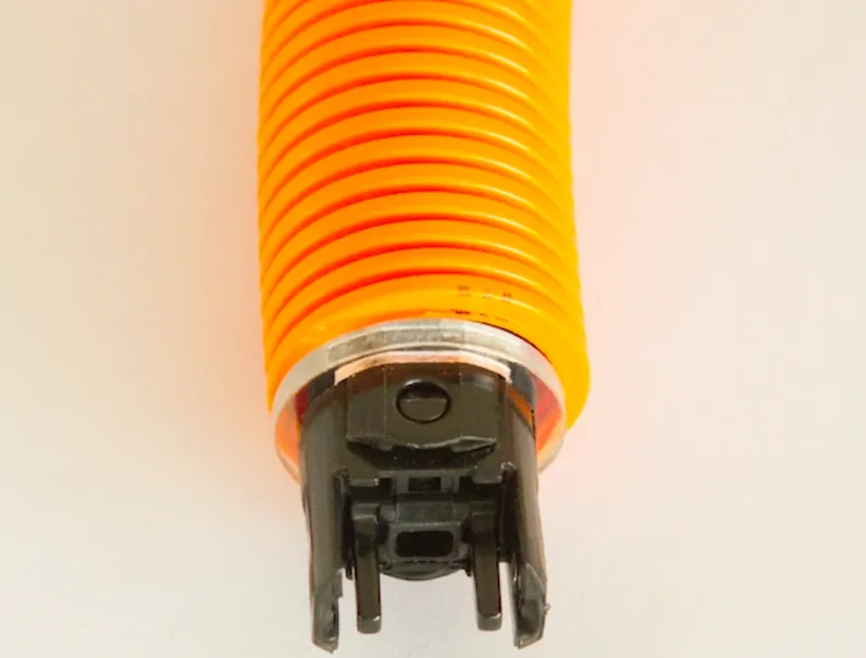Close-up of the Rolliner conduit end showing the orange corrugated PA12 hose meeting a black snap-fit connector coupling, the tool-free connection point